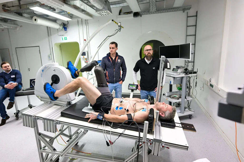 man with prosthetic leg lies on a table pedaling a horizontal bike device