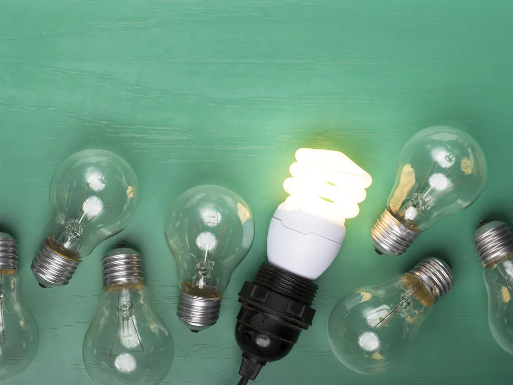 Incandescent light bulbs with one energy-efficient lightbulb glowing