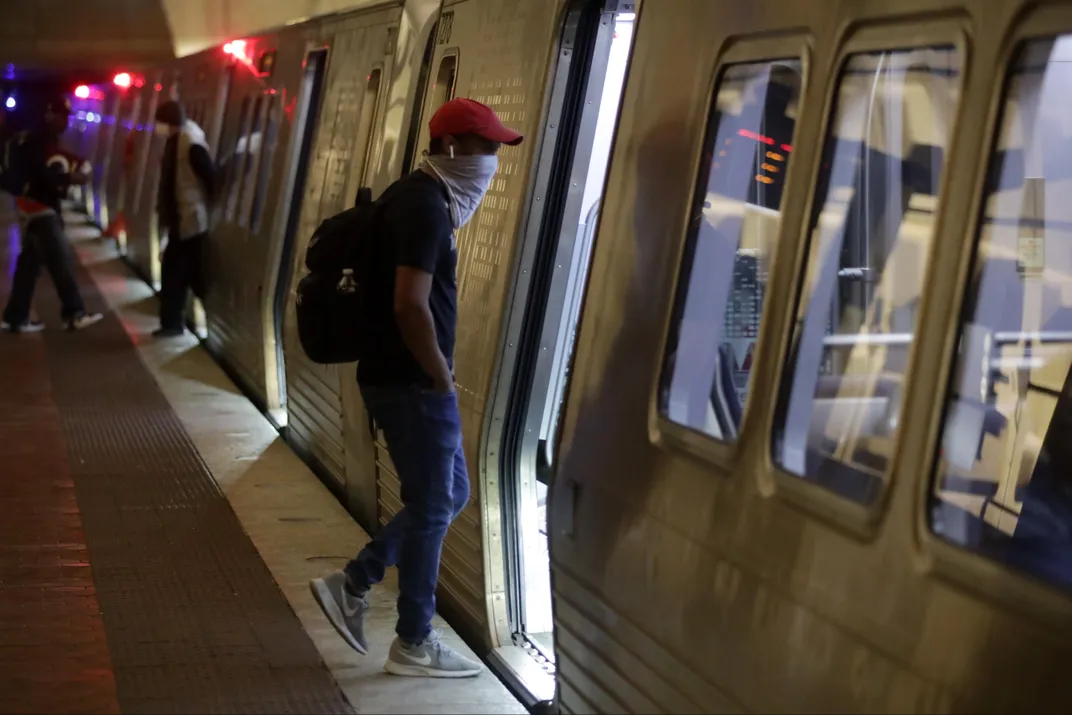 A Metro rider wearing a masks enters a subway car in D.C.