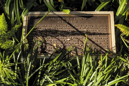 Sunlight illuminates a plaque in Charleston, South Carolina, honoring 36 likely enslaved people&mdash;ranging in age from 3 to over 50&mdash;whose remains were discovered in 2013.