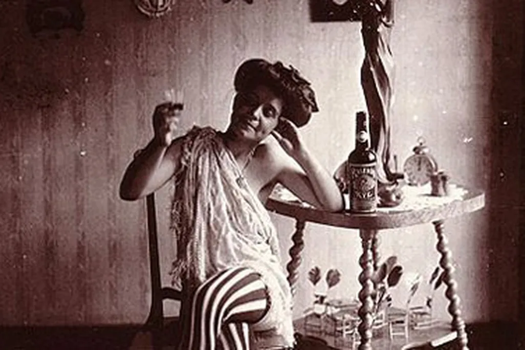 Storyville. Seated woman wearing striped stockings, drinking "Raleigh" Rye.