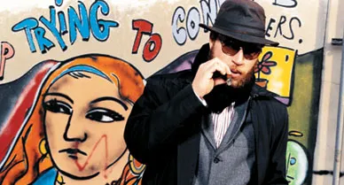 “I like the idea of the artist going out in the world, creating a dialogue,” says De La Vega (in the East Village with one of his street paintings). “Art is interacting with people.”