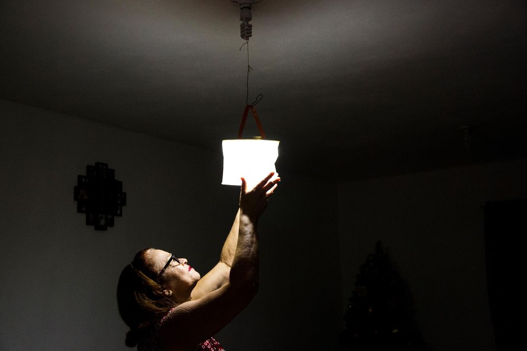 A woman hangs a solar lamp