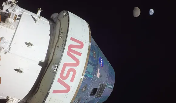 Artemis 1 Orion spacecraft with Earth and Moon in the distance.