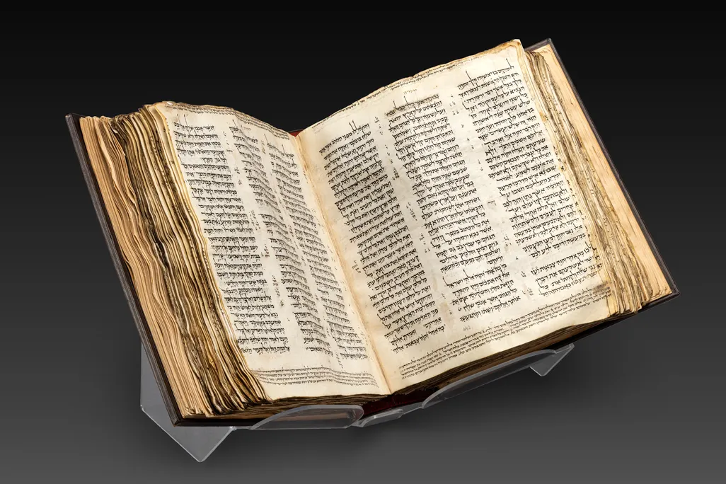Bible open to a page in the middle, set against a black backdrop