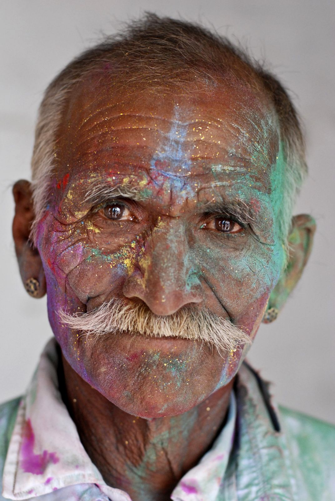 a portrait of a man with colorful powder on his face