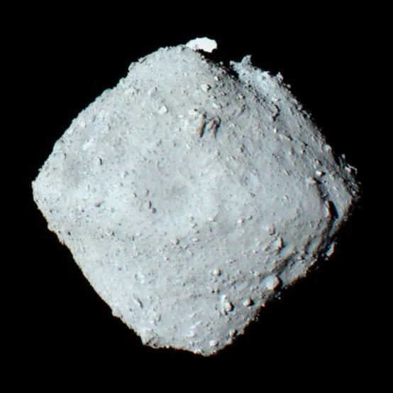 An image of the asteroid 162173 Ryugu  as it appears in space. The asteroid looks like a grey diamond shaped chunk.