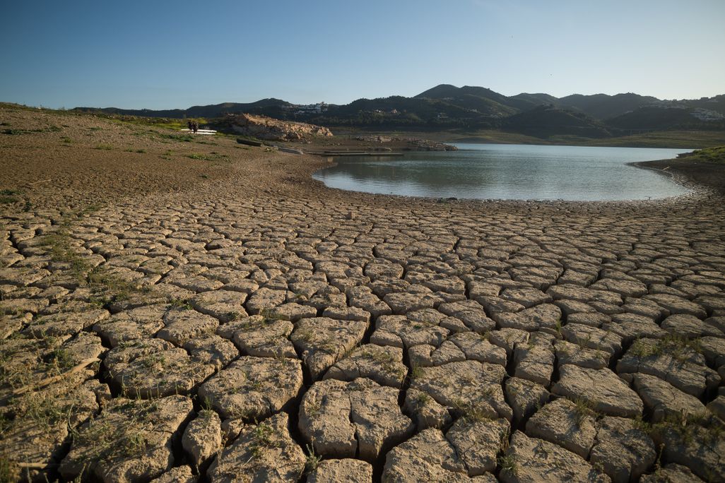 dry, cracked ground on the shores of a heavily receded reservoir in eastern Spain.