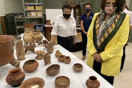 Costa Rican Minister of Culture and Youth Sylvie Durán (right) examines some of the newly returned artifacts.