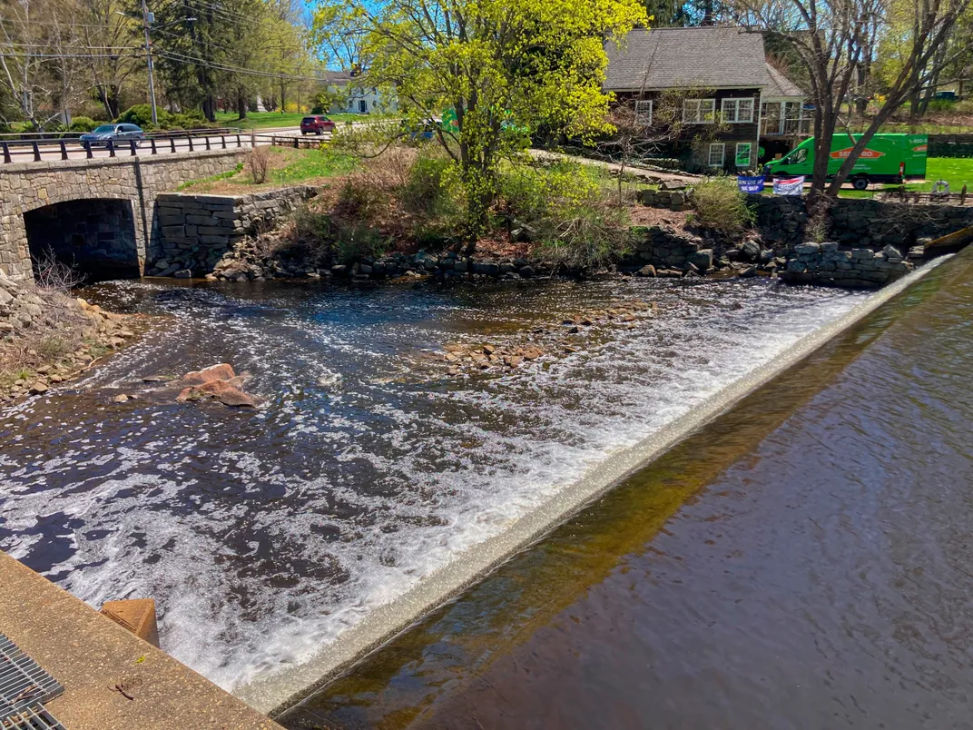 a dam on a river with a bridge crossing it downstream