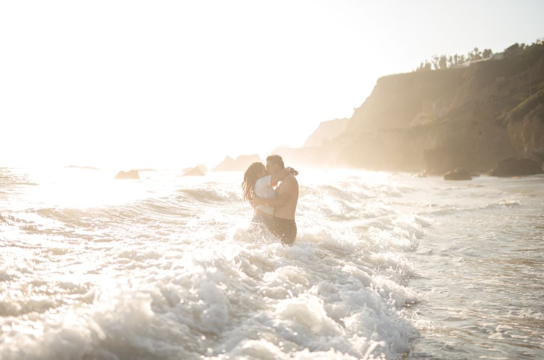 10 - Like in a scene from a movie, waves crash and the sun shines as a couple reunites on the beach.