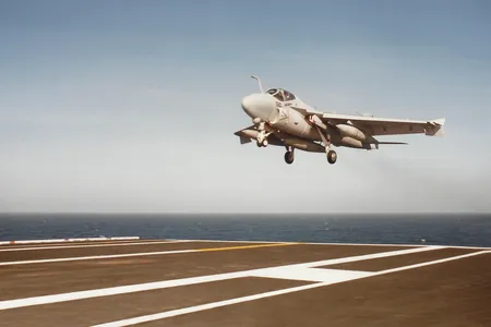 Intruder NE 510, with speed brakes deployed, lands on the USS Ranger.
