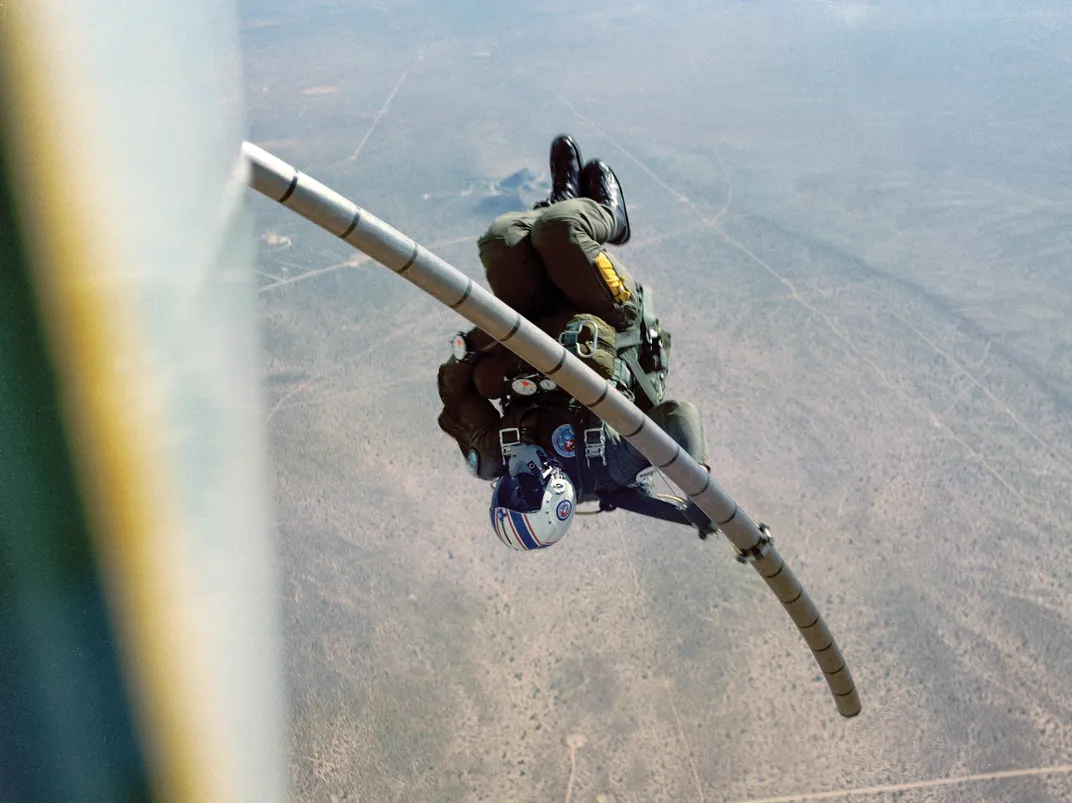 Navy parachutist slides down a telescoping pole