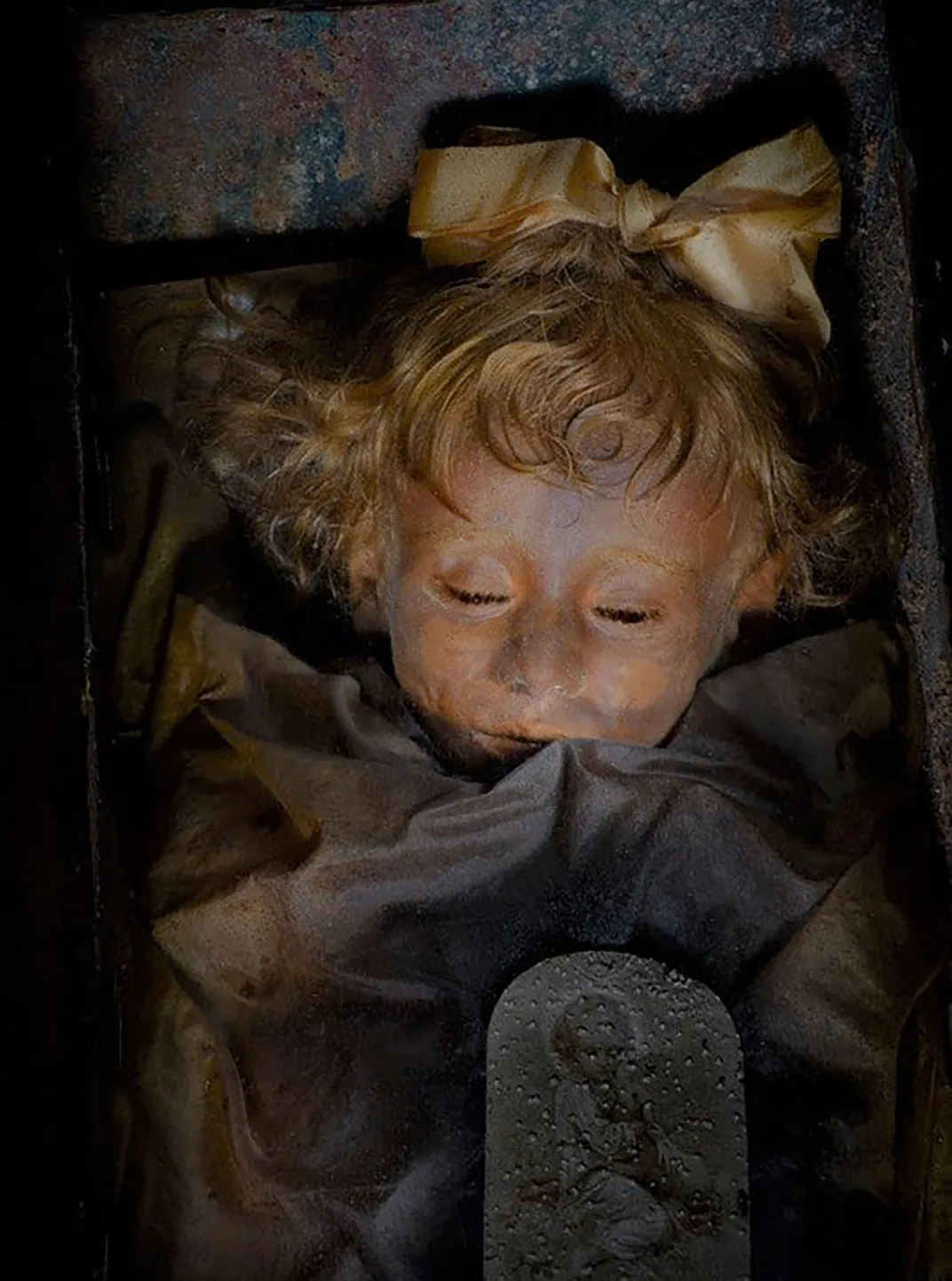 Well-preserved body of young girl with gold hair ribbon