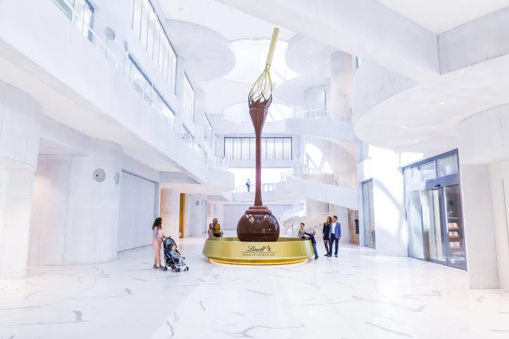The entrance to the Lindt Home of Chocolate includes a 30-foot chocolate fountain topped with a giant golden whisk 