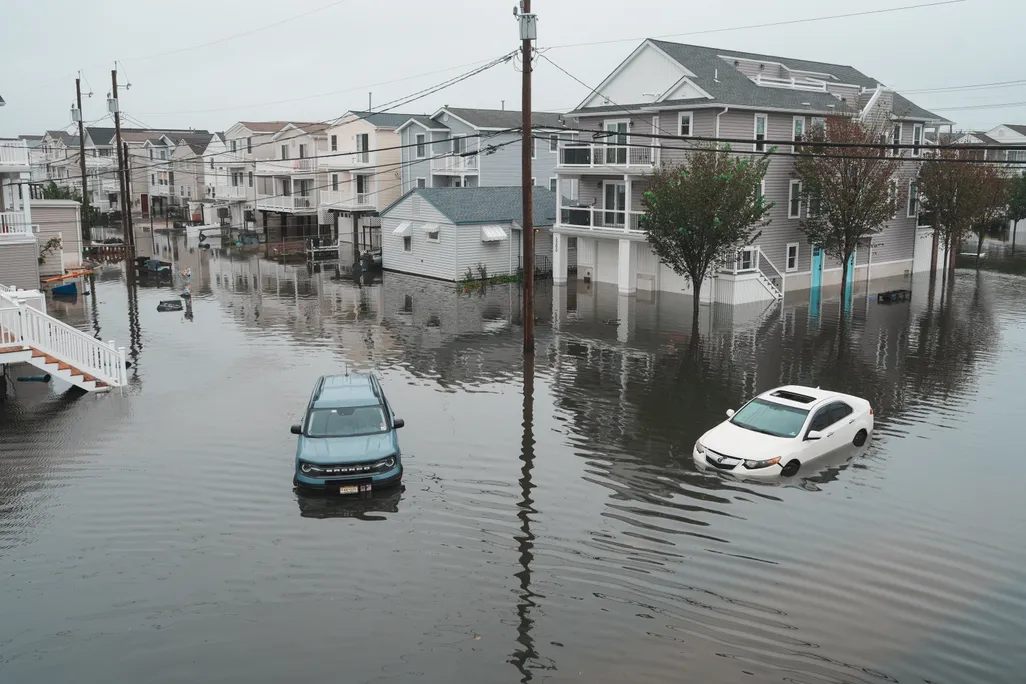 a flooded street with houses and cars
