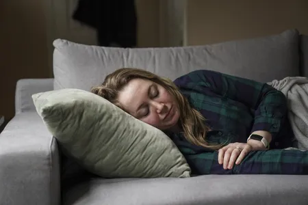 A woman with long Covid, suffering symptoms including extreme fatigue and brain fog, rests on her couch on February 3, 2022.