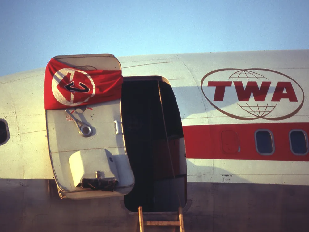 The Popular Front for the Liberation of Palestine's flag hangs on the door of a hijacked TWA Boeing 707 at Dawson's Field in Libya in September 1970.
