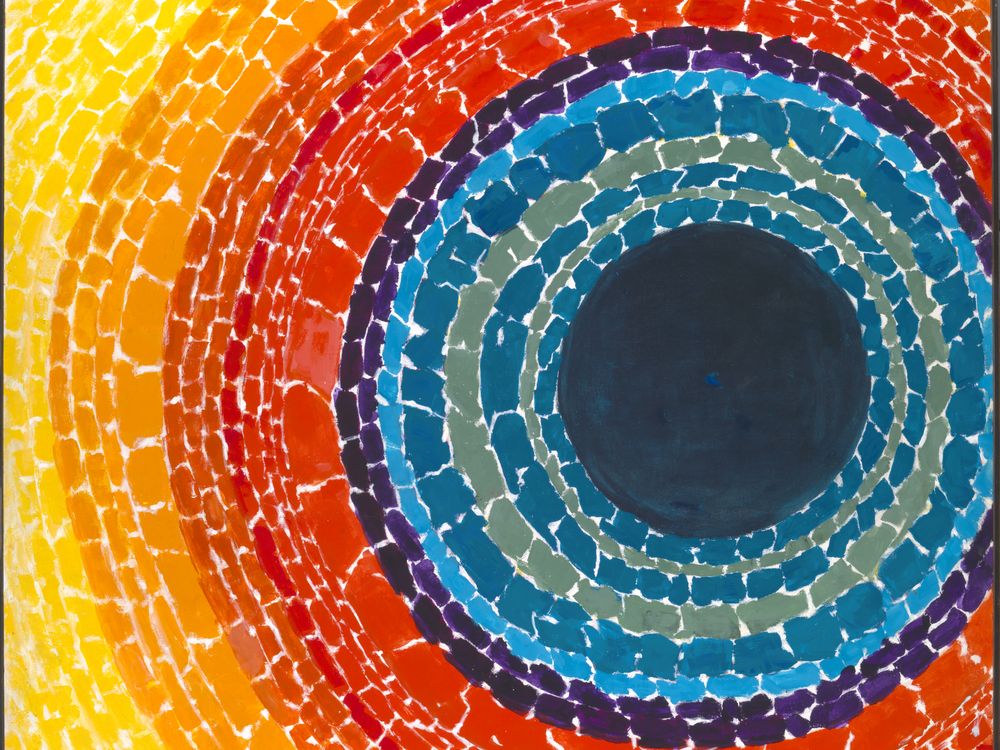 Painting with a dark blue center circle surrounded by concentric circles of reds, oranges, and yellow