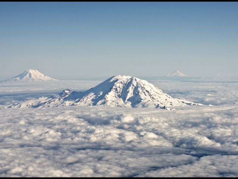 Aerial shot of Mt Rainier, Mt Adams, Mt Hood and Mt St Helens in the ...