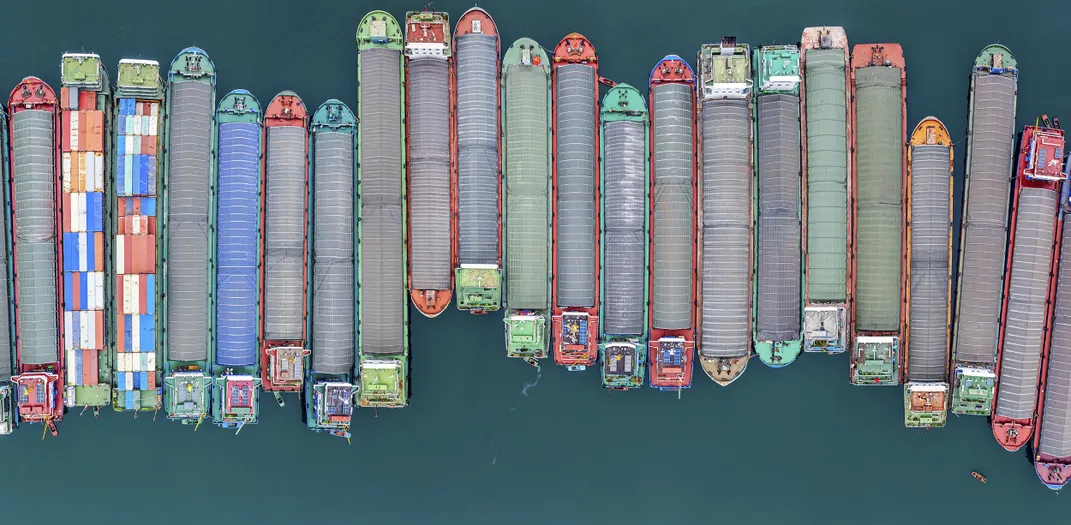 Cargo ships are neatly arranged at a port by the Yangtze River, waiting for cargo.
