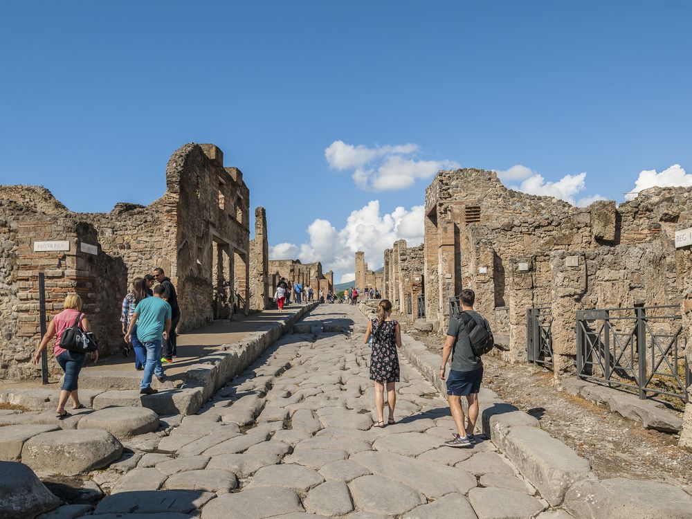 Travelers walking among the ruins at Pompeii