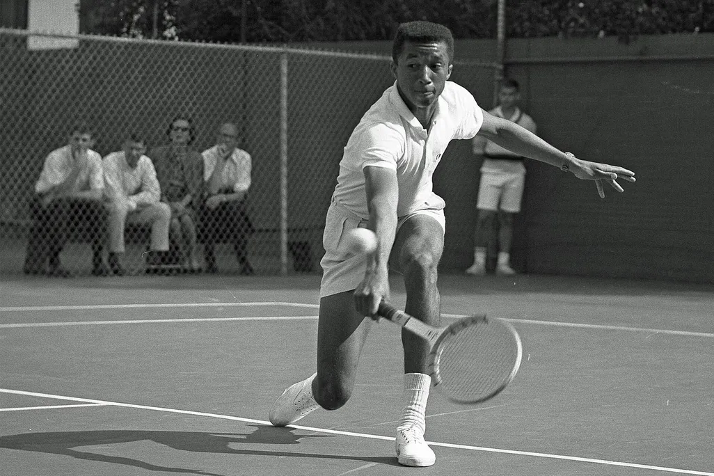 Arthur Ashe playing tennis against Dennis Ralston in 1964