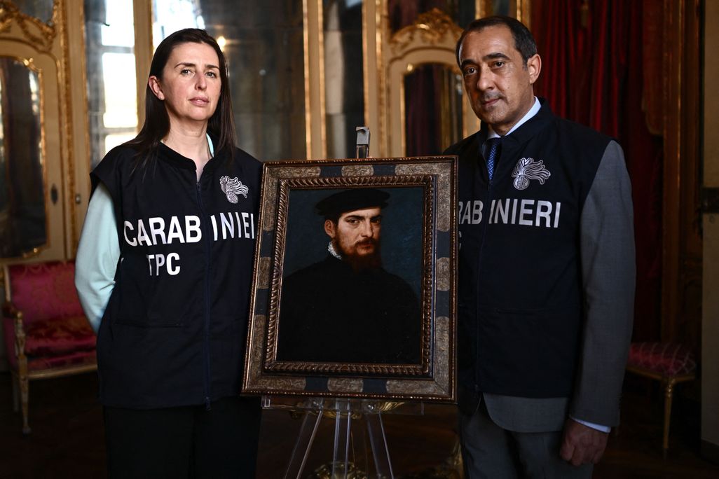 Members of the Carabinieri Police Cultural Heritage Protection Unit pose with a painting