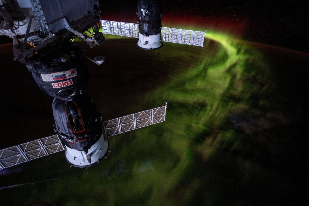 Soyuz crew vehicle and supply craft with auroras
