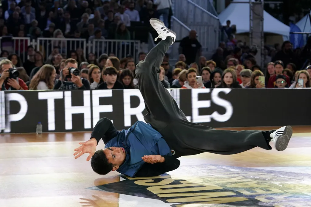 A man dancing on the ground in front of an audience