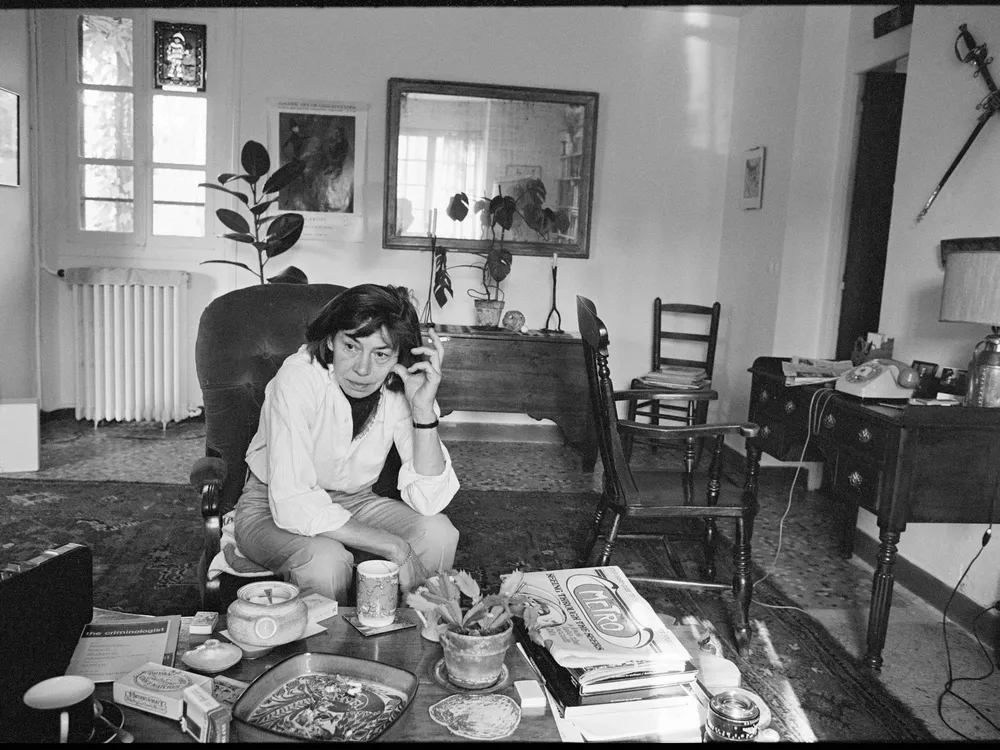 Portrait of American novelist Patricia Highsmith as she sits in the living room of her home in France.