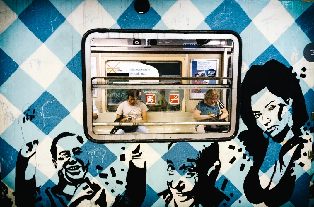 People sit inside a blue subway car