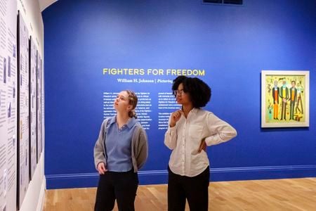 Visitors look at a timeline of William H. Johnson's life