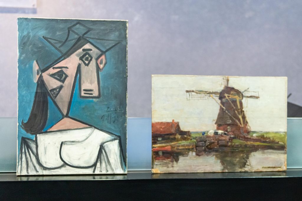 The Cubist bust portrait sits vertically next to the short horizontal Mondrian canvas, a gray- and green-toned depiction of a windmill over a body of water