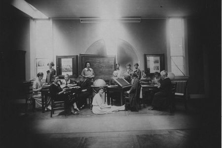 Margaret Harwood sits on the floor for this posed tableau taken on May 19, 1925. Harvia Wilson is at far left, sharing a table with Annie Cannon (too busy to look up) and Antonia Maury (left foreground). The woman at the drafting table is Cecilia Payne.