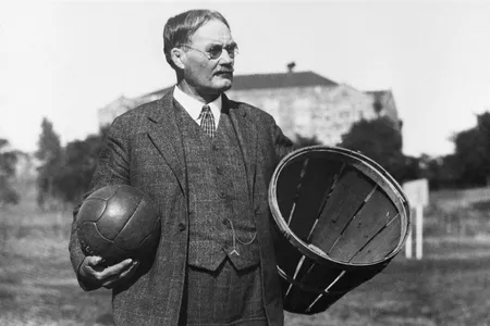 James Naismith, the inventor of basketball, holding a soccer ball and a basket