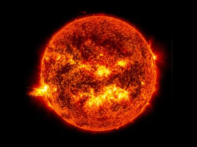 A solar flare erupts from the sun on June 20, 2013, seen at the left of the image.