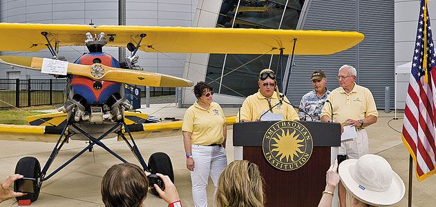 An emotional Gene Breiner (at lectern, with daughter Joyce and General Jack Dailey, director of the National Air and Space Museum) donated Plane Jane to the Museum this past June in hopes of inspiring future pilots.