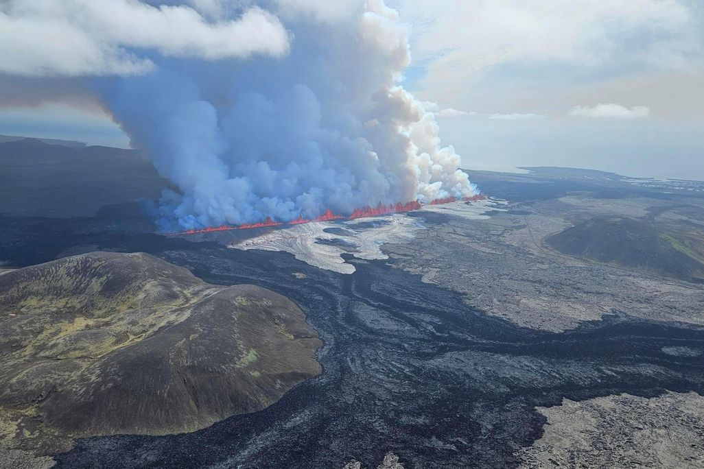 Aerial photo of lava and spurting from the ground and smoke rising above it