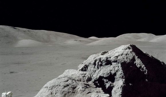 Jack Schmitt picking up the gnomon after collecting samples. This view is to the west toward the Lee Lincoln Scarp. Apollo image AS17-140-21496.