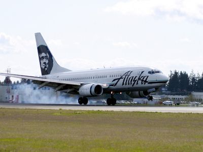 A gray-bellied Alaska Airlines Boeing 737 touches down at Seattle-Tacoma International Airport.