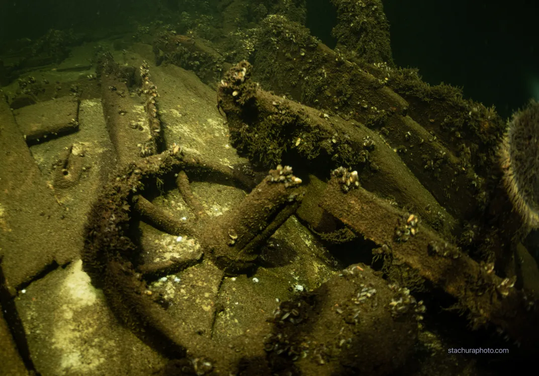 Underwater view of what appears to be an old ship's steering wheel