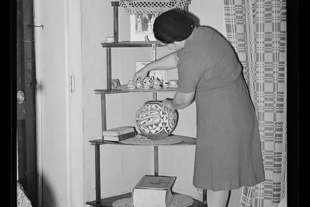 Woman arranging bric-a-brac in her Arizona home circa 1940