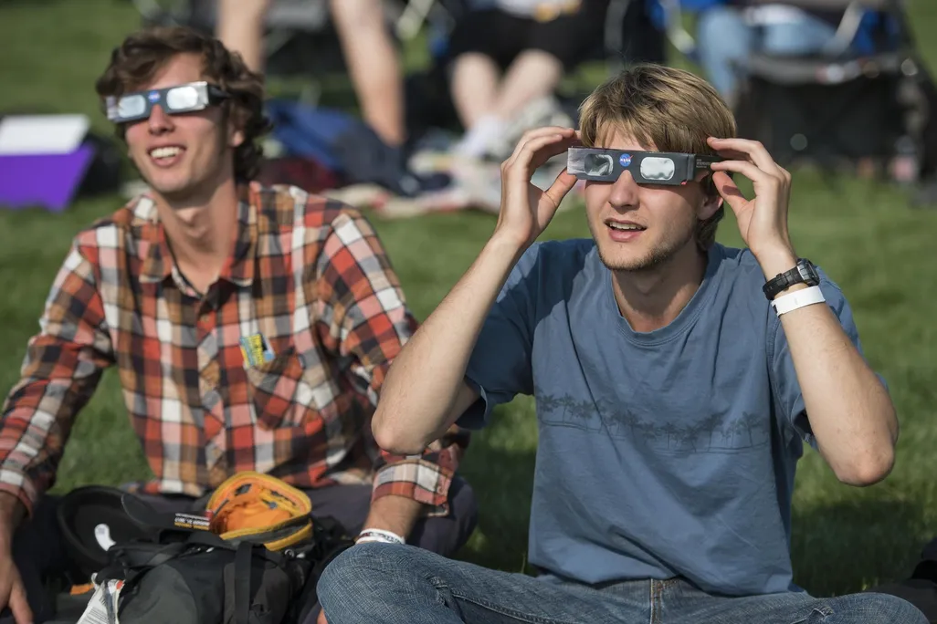 Two men wearing eclipse glasses