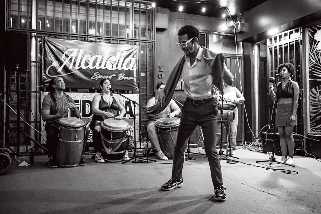 A black and white photograph of a person dancing to the bomba