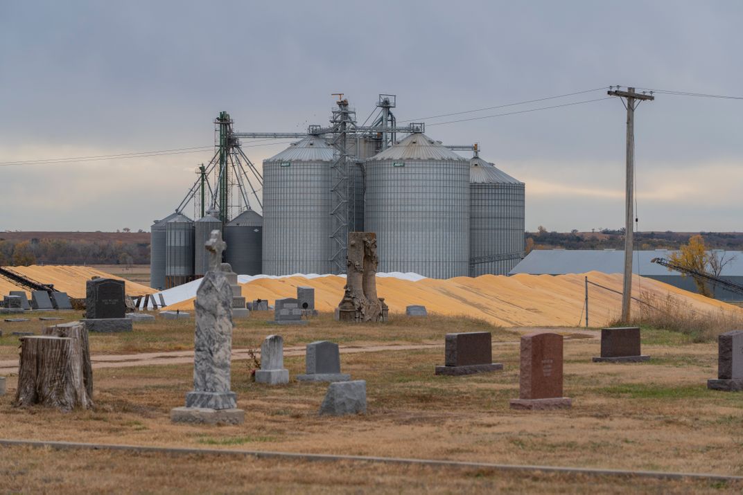 a cemetery sits in front of grain silos
