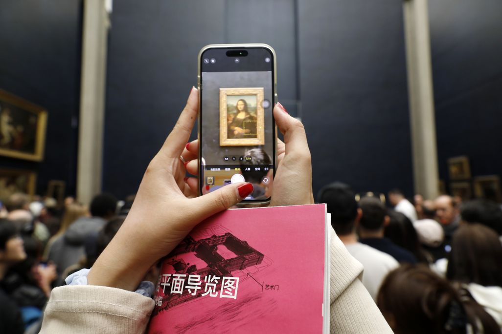 Tourists take pictures of Leonardo da Vinci s Mona Lisa painting at the Louvre Museum during the reopening of the Parisian museum on October 26, 2025 in Paris, France.