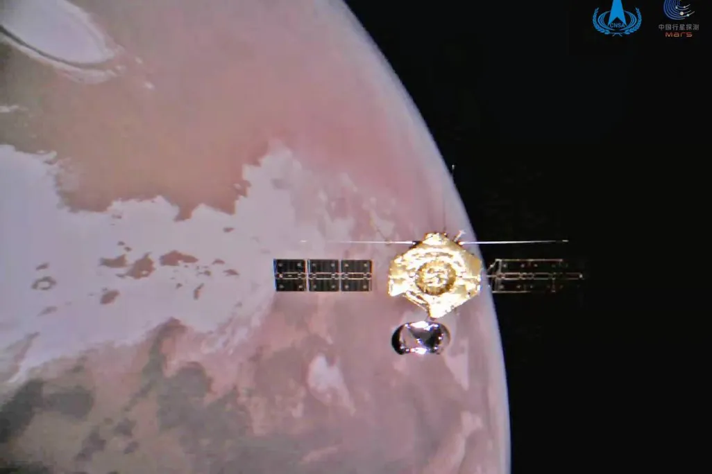 An image of the Tianwen-1 orbiter orbiting above the Martian surface