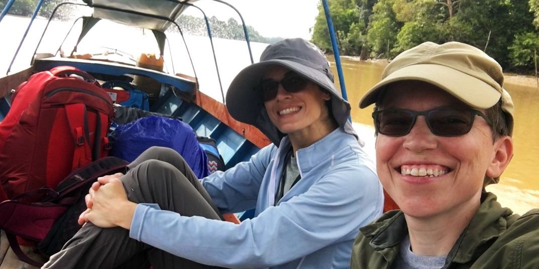 Animal keeper Alex Reddy and curator of primates Meredith Bastian travel on a boat