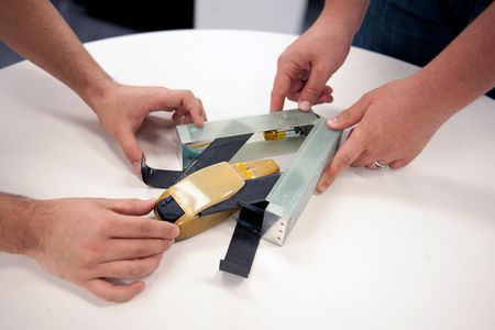 MIT graduate students load a micro-drone into its deployment canister.